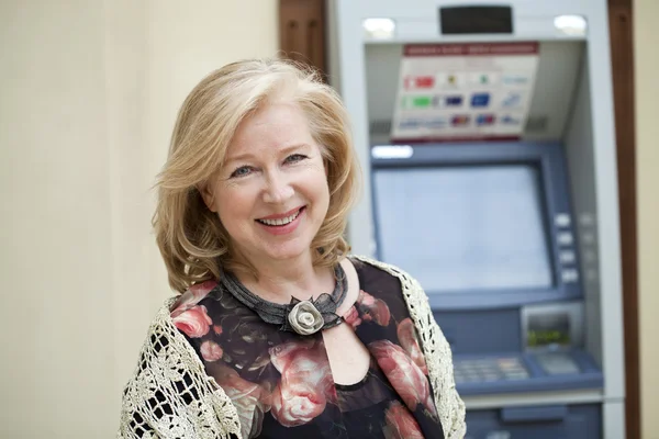 Mogen blond kvinna nära Atm — Stockfoto