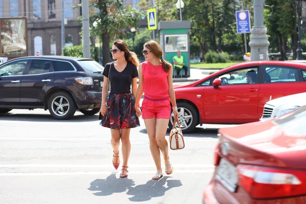 Two young girls girlfriends cross the road — Stock Photo, Image