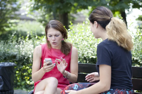 Junge Frau ruht sich auf Bank im Park aus — Stockfoto