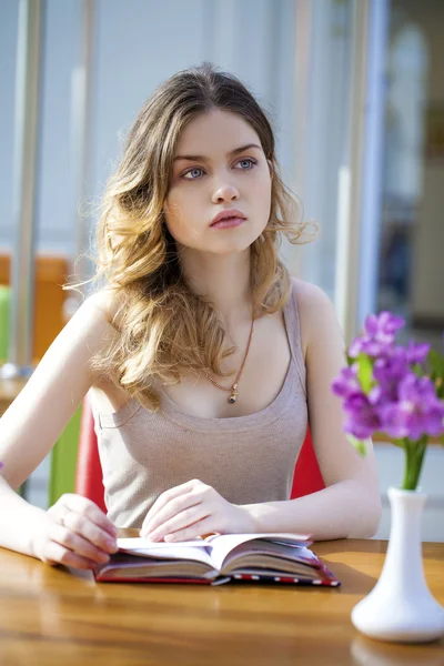 Mooie jonge vrouw zitten in het café — Stockfoto