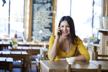  Bir kafede oturan güzel esmer kız