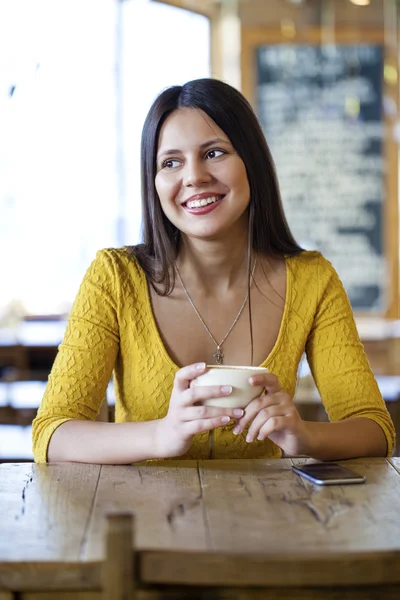 Mulher bonita sentada em uma cafeteria e beber chá — Fotografia de Stock