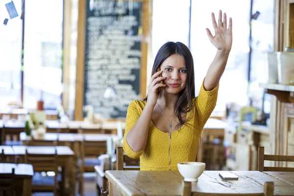 Mooie brunette meisje, zittend in een koffieshop — Stockfoto