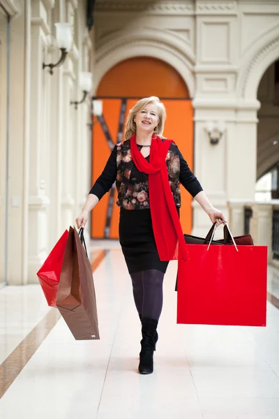 Madura feliz mujer con bolsas de compras —  Fotos de Stock