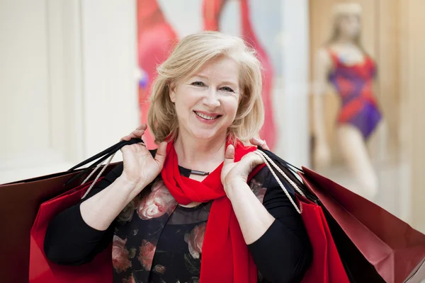 Mature happy woman with shopping bags — Stock Photo, Image