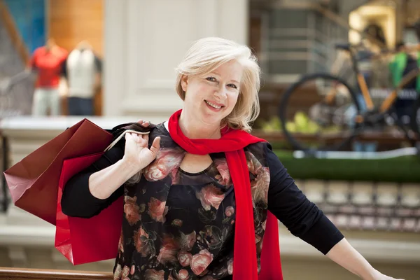 Madura feliz mujer con bolsas de compras —  Fotos de Stock