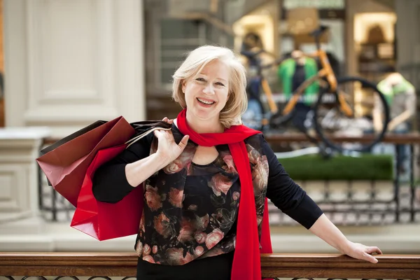 Mulher feliz madura com sacos de compras — Fotografia de Stock