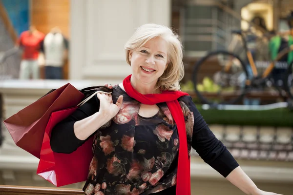 Madura feliz mujer con bolsas de compras —  Fotos de Stock