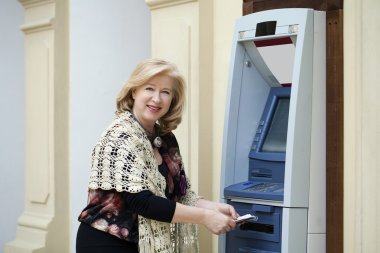 Olgun sarışın kadın yakınındaki Atm para sayma