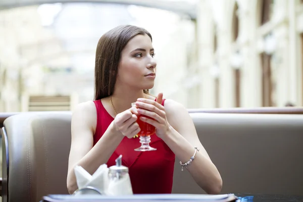 Hermosa chica morena sentada en una cafetería — Foto de Stock