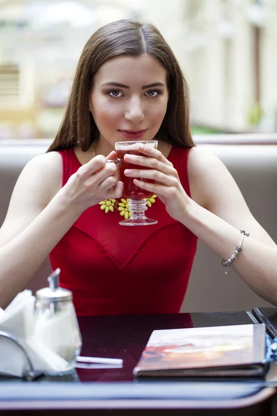 Hermosa chica morena sentada en una cafetería —  Fotos de Stock