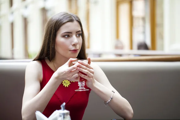 Menina morena bonita sentada em uma cafeteria — Fotografia de Stock