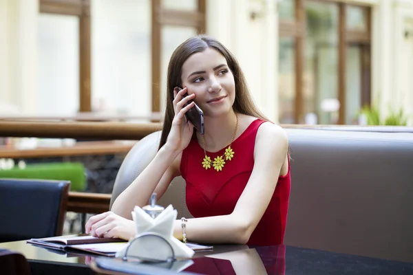 Mooie brunette meisje, zittend in een koffieshop — Stockfoto