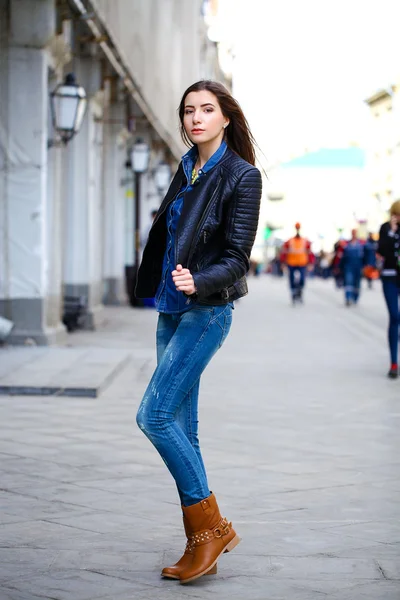 Joven hermosa chica en pantalones vaqueros azules y una camisa azul en la espalda —  Fotos de Stock