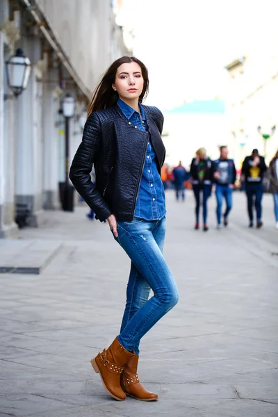 Young beautiful girl in blue jeans and a blue shirt on the backg — Stock Photo, Image