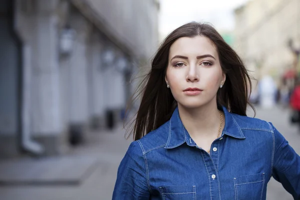 Porträtt av en vacker ung kvinna i en blå jeans skjorta på den — Stockfoto