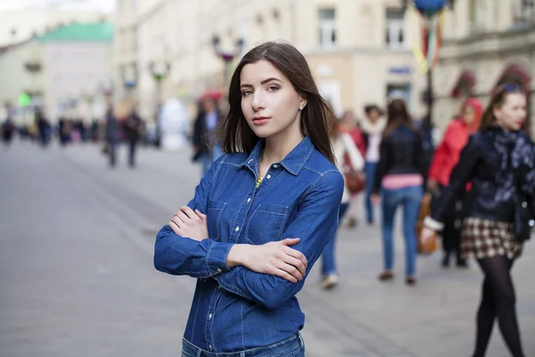 Retrato de uma bela jovem mulher em uma camisa jeans azul no — Fotografia de Stock
