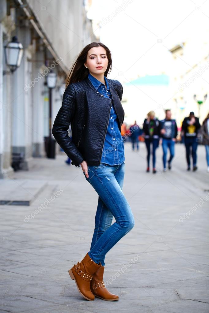 Young beautiful girl in blue jeans and a blue shirt on the backg ...