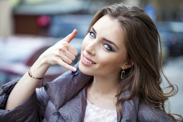 Beautiful happy brunette woman making a call me gesture — Stock Photo, Image
