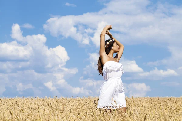 Mujer joven en un campo de trigo dorado — Foto de Stock