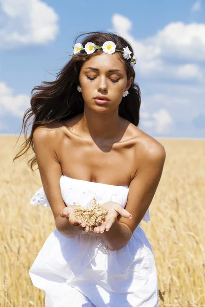 Jovem mulher em um campo dourado de trigo — Fotografia de Stock