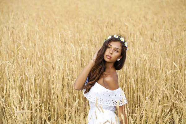 Portret van een mooie jonge brunette in een tarweveld close-up — Stockfoto