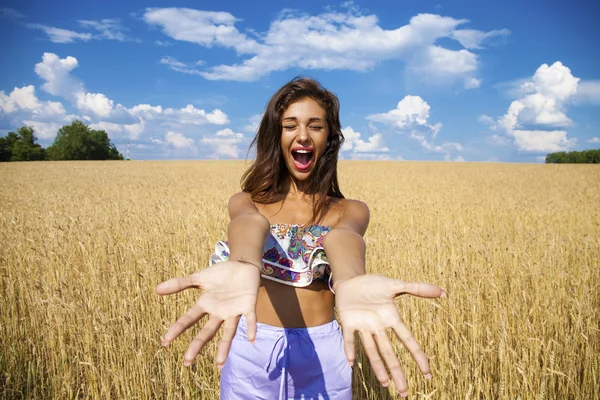 Glad ung kvinna i ett vete gyllene fält — Stockfoto