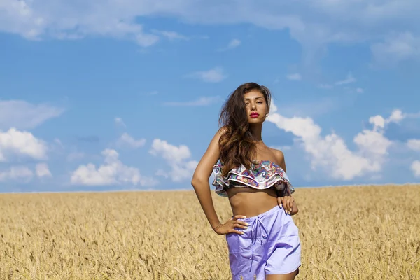 Sexy jeune femme en short bleu dans un champ de blé doré — Photo