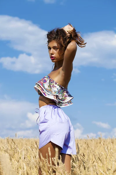 Sexy giovane donna in pantaloncini blu in un campo d'oro di grano — Foto Stock