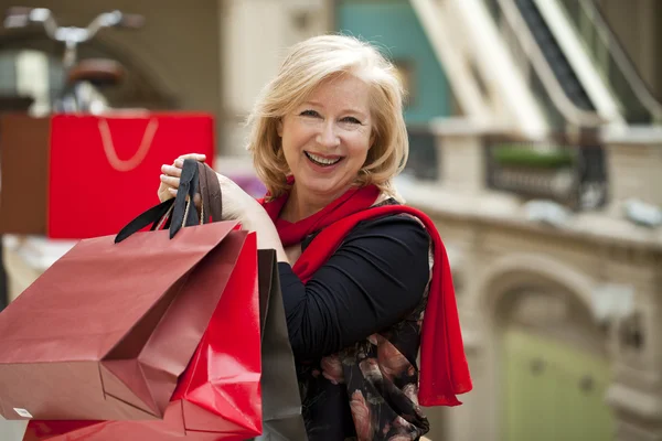 Mulher feliz madura com sacos de compras — Fotografia de Stock