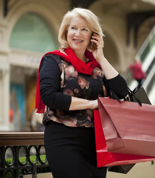 Volwassen gelukkig vrouw met shopping tassen — Stockfoto