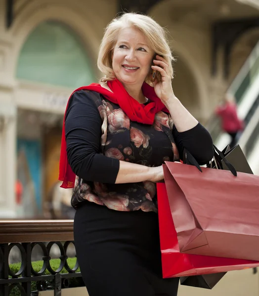 Madura feliz mujer con bolsas de compras —  Fotos de Stock