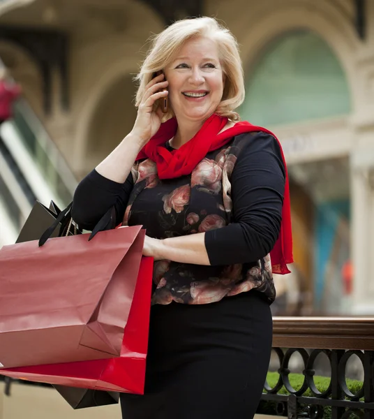 Madura feliz mujer con bolsas de compras —  Fotos de Stock