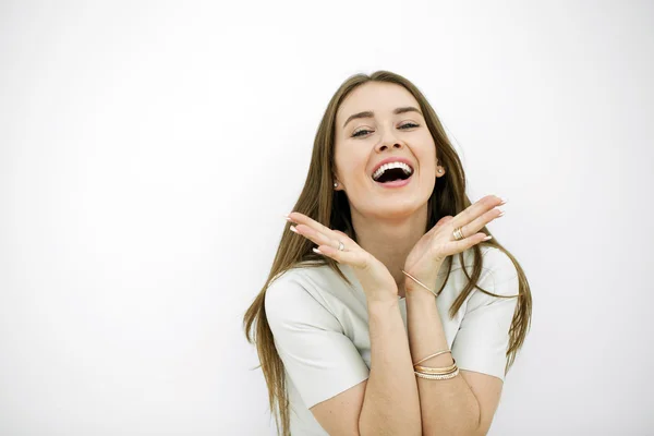 Mulher feliz bonita jovem posando contra uma parede branca — Fotografia de Stock