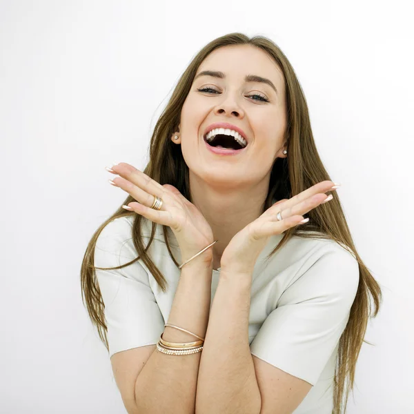 Mulher feliz bonita jovem posando contra uma parede branca — Fotografia de Stock