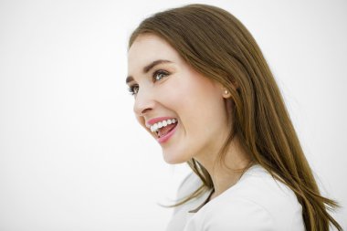 Güzel genç mutlu kadın beyaz bir duvara poz