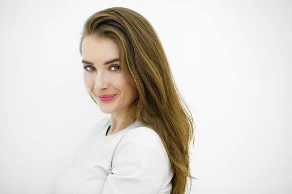 Beautiful young happy woman posing against a white wall — Stock Photo, Image