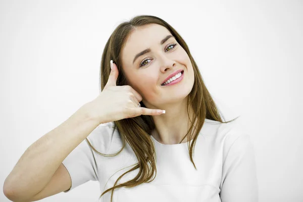 Young happy smiling brunette woman with call me gesture — Stock Photo, Image