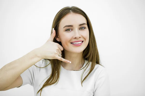 Junge glücklich lächelnde brünette Frau mit Anruf mich Geste — Stockfoto