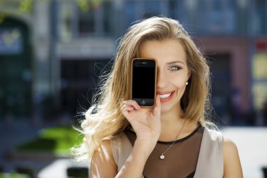 Genç kadın onun yüz ekran smartphone kapsar