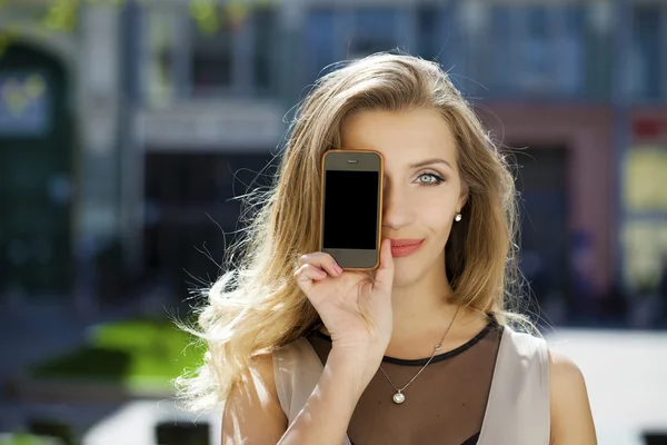 Mujer joven cubre su teléfono inteligente pantalla de la cara — Foto de Stock