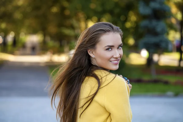 Glückliche junge Frau in gelbem Mantel in der Herbststraße — Stockfoto