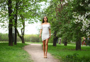 Beyaz elbiseli bahar Park'ta yürüyordunuz mutlu genç kadın