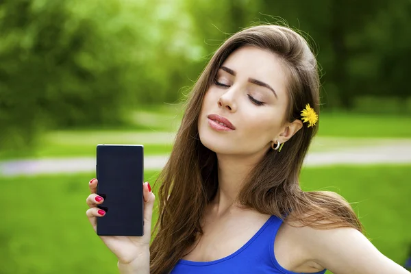 Genç güzel esmer kadın yeni bir akıllı telefon gösterir — Stok fotoğraf