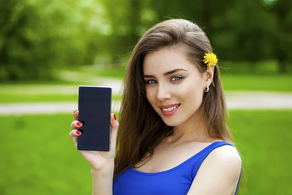 Fiatal gyönyörű barna nő azt mutatja, hogy egy új intelligens telefon — Stock Fotó