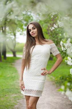 Arka plan bahar f karşı beyaz elbiseli mutlu genç kadın