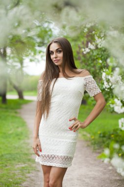 Arka plan bahar f karşı beyaz elbiseli mutlu genç kadın