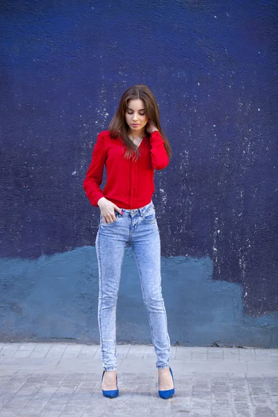 Молодая красивая девушка в синих джинсах и красная рубашка на заднем сиденье — стоковое фото