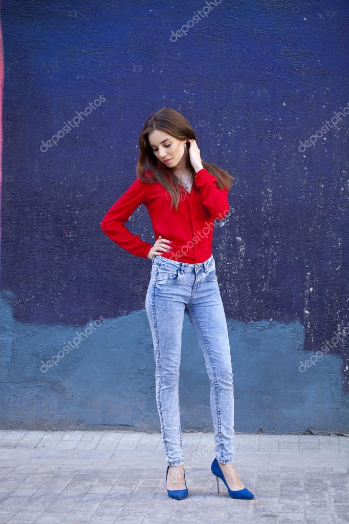 Diligence kan opfattes børn Young beautiful girl in blue jeans and a red shirt on the backgr Stock  Photo by ©arkusha 72901919