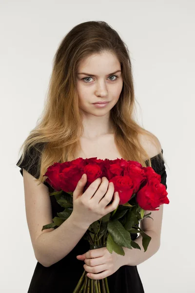 Retrato de uma jovem menina bonita com um buquê de rosas vermelhas — Fotografia de Stock